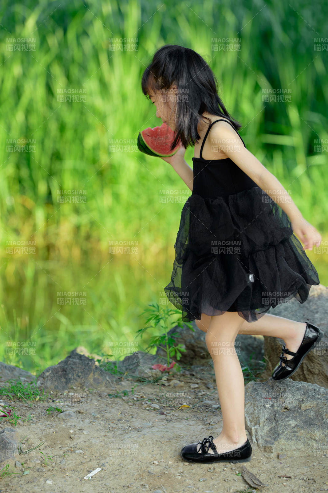 夏季在户外游玩吃西瓜的可爱亚洲女童