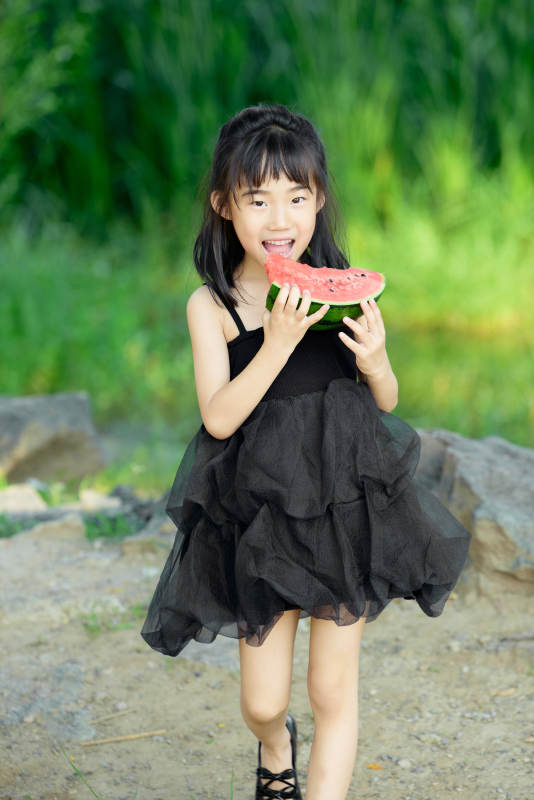 夏季在户外游玩吃西瓜的可爱亚洲女童