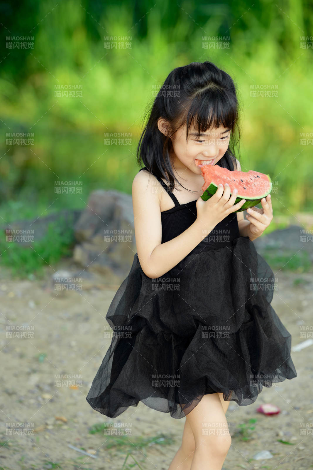 夏季在户外游玩吃西瓜的可爱亚洲女童