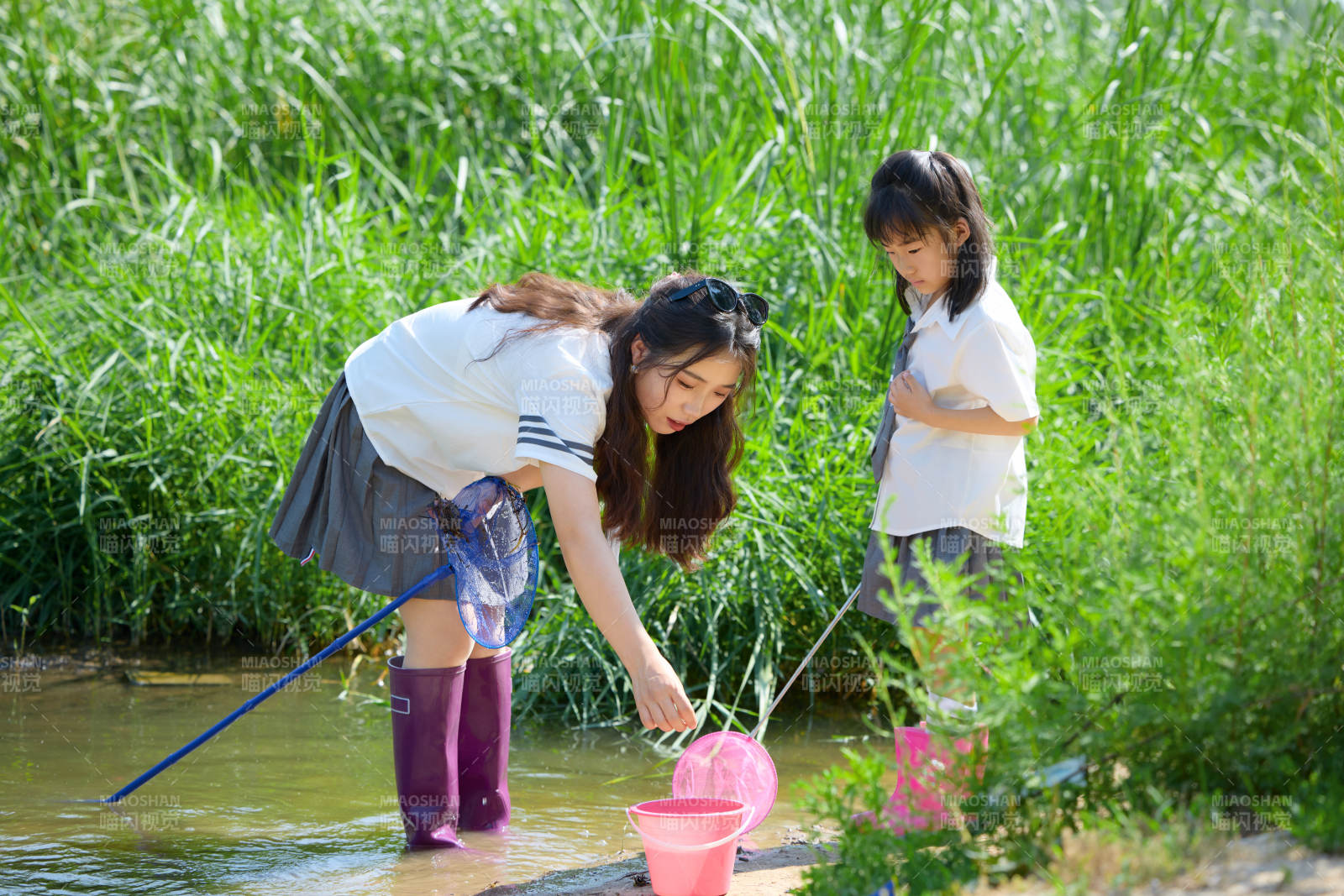 夏天在戶外溪流捕捉魚蝦的母女親子