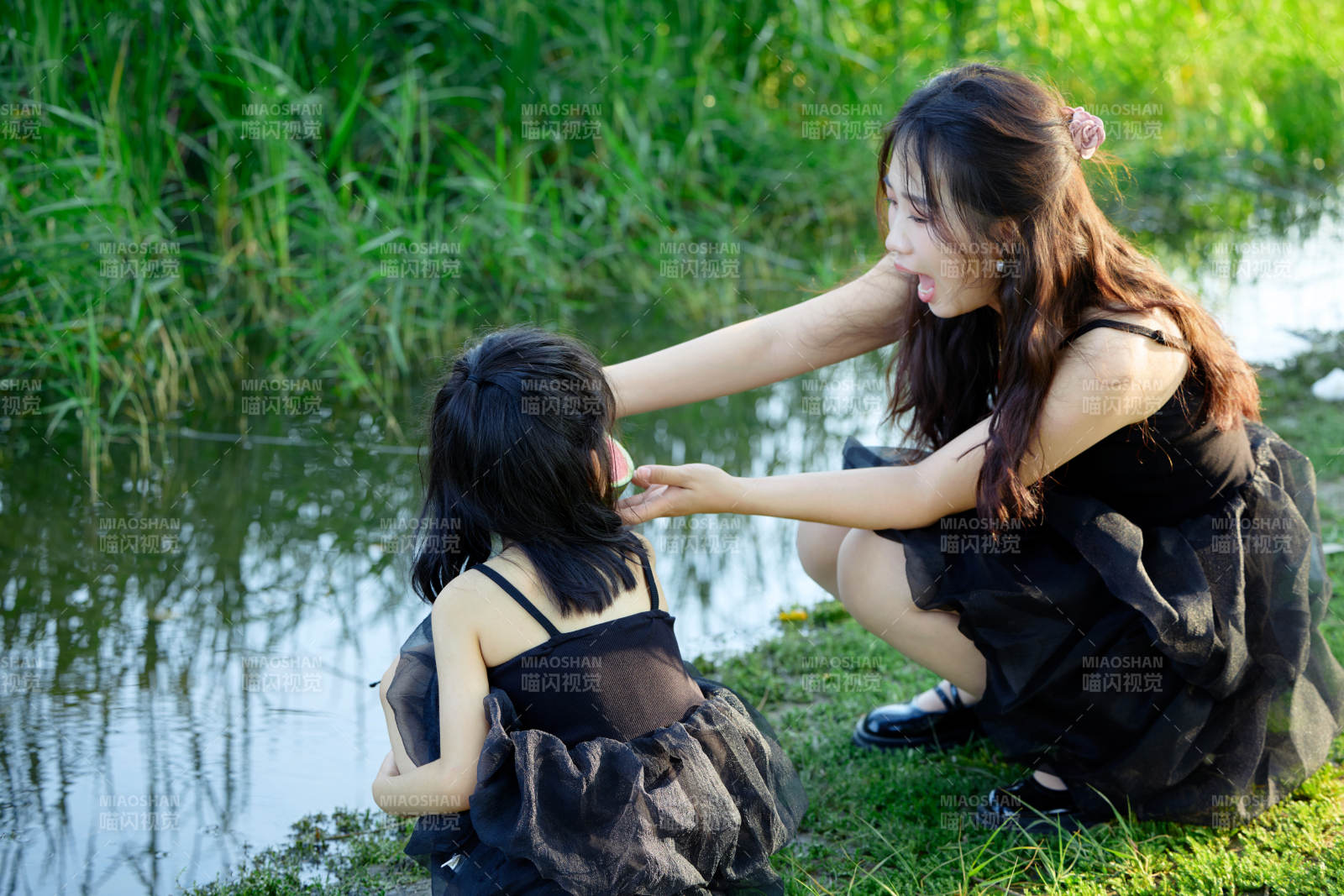 夏天在戶外公園吃西瓜的亞洲母女親子