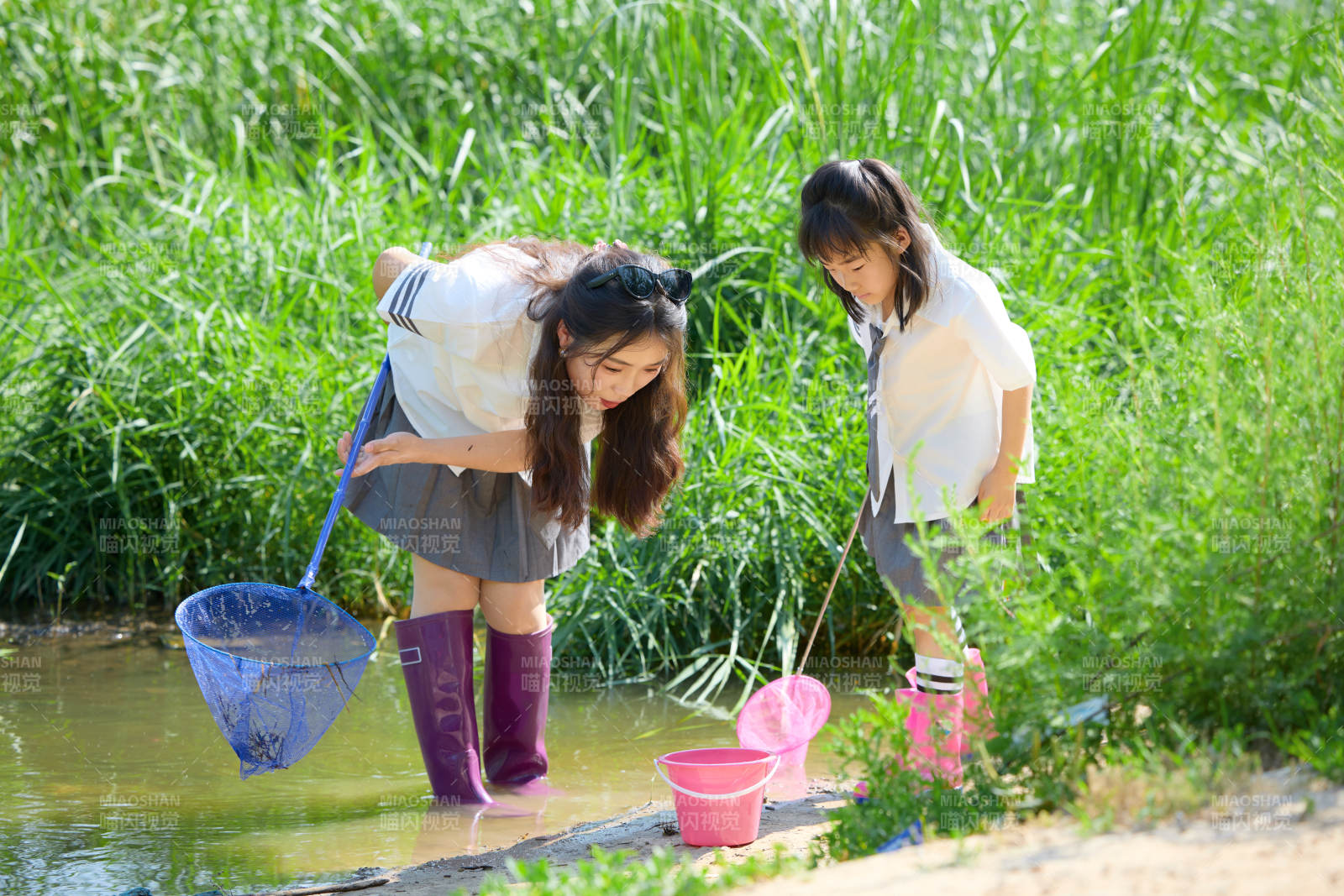 夏天在戶外溪流捕捉魚蝦的母女親子