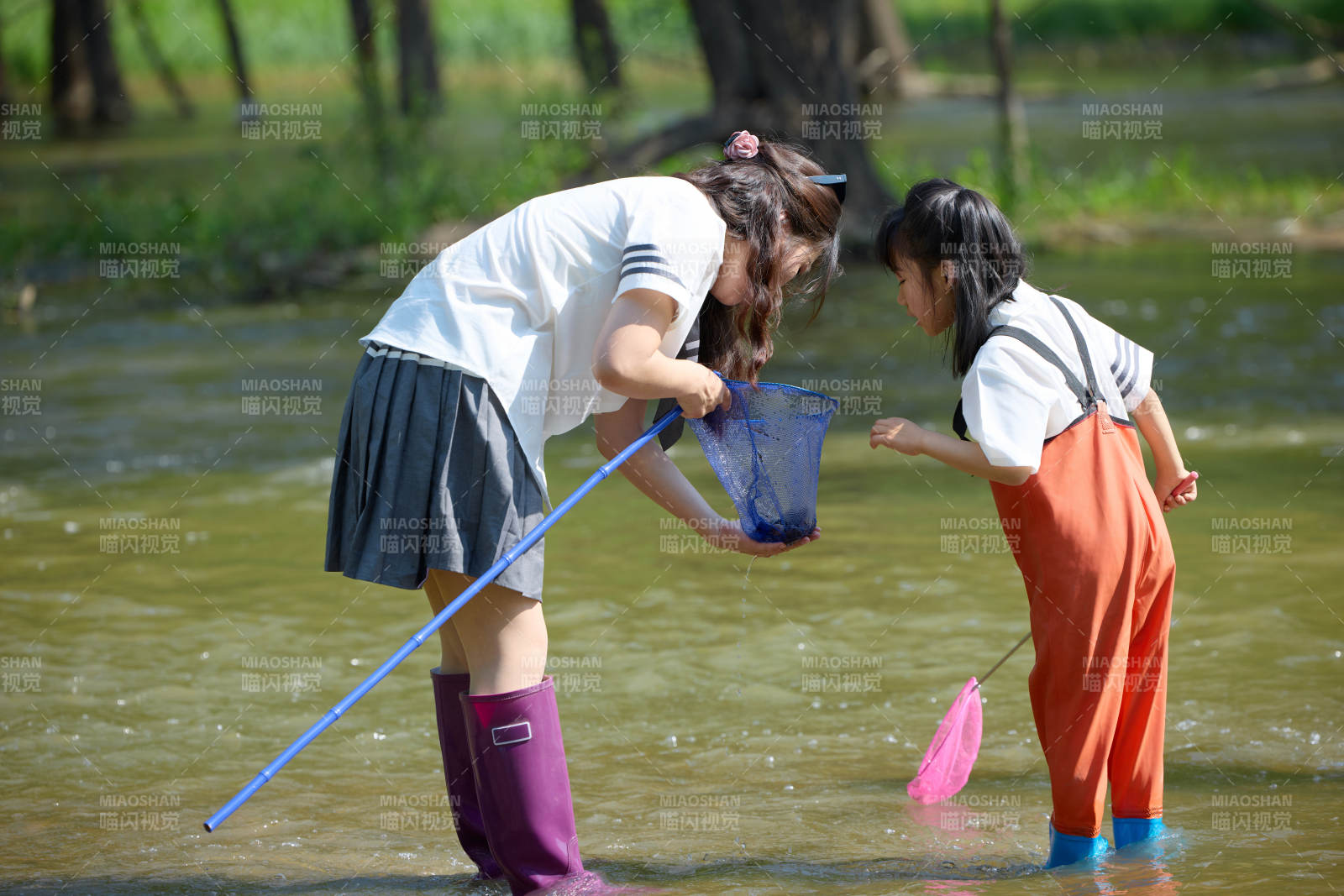夏天在戶外溪流捕捉魚蝦的母女親子