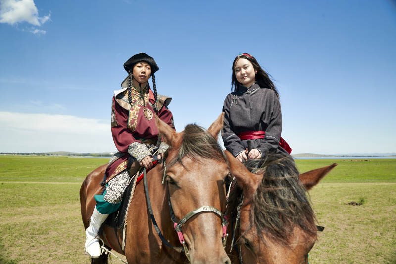 草原那达慕大会上骑着马的蒙古演员