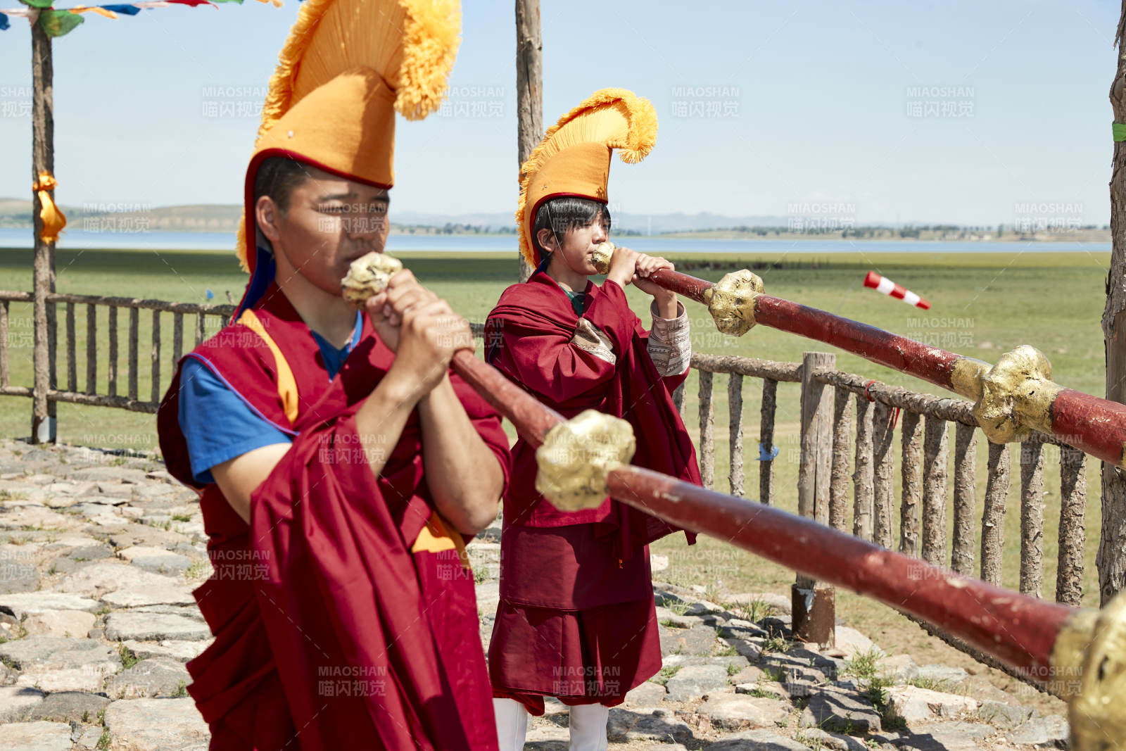 在敖包上吹響銅號(hào)的喇嘛僧人