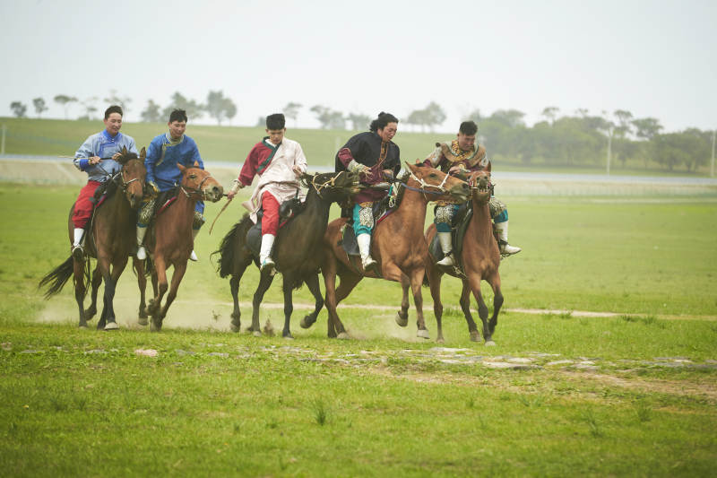 草原那达慕大会上骑着马的蒙古演员