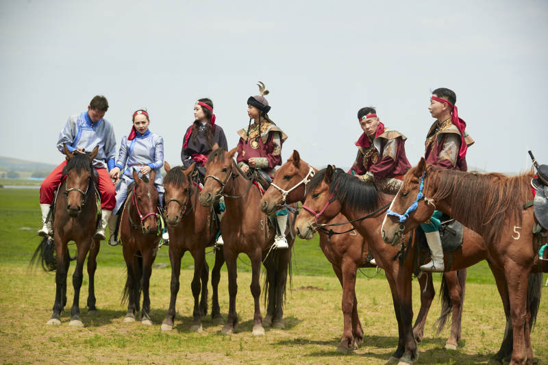 草原那达慕大会上骑着马的蒙古演员