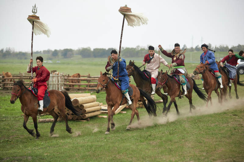 草原那达慕大会上骑着马的蒙古演员