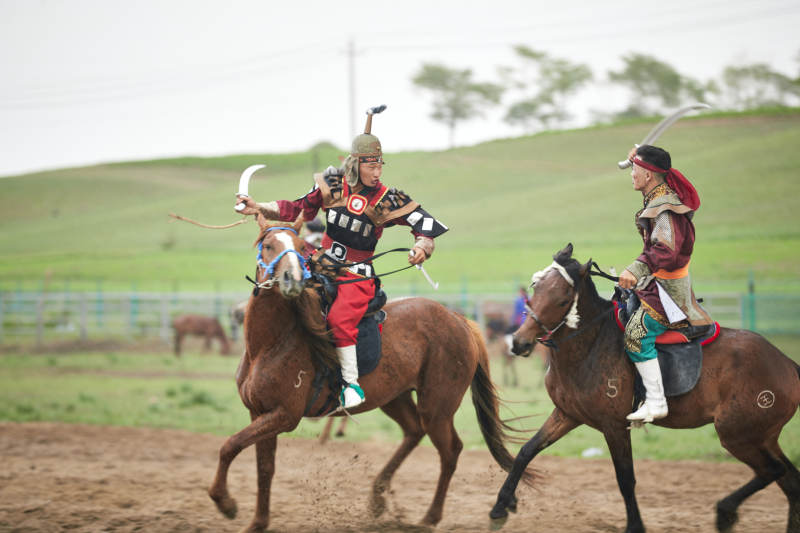 在草原景区表演的蒙古古代骑马打仗演出