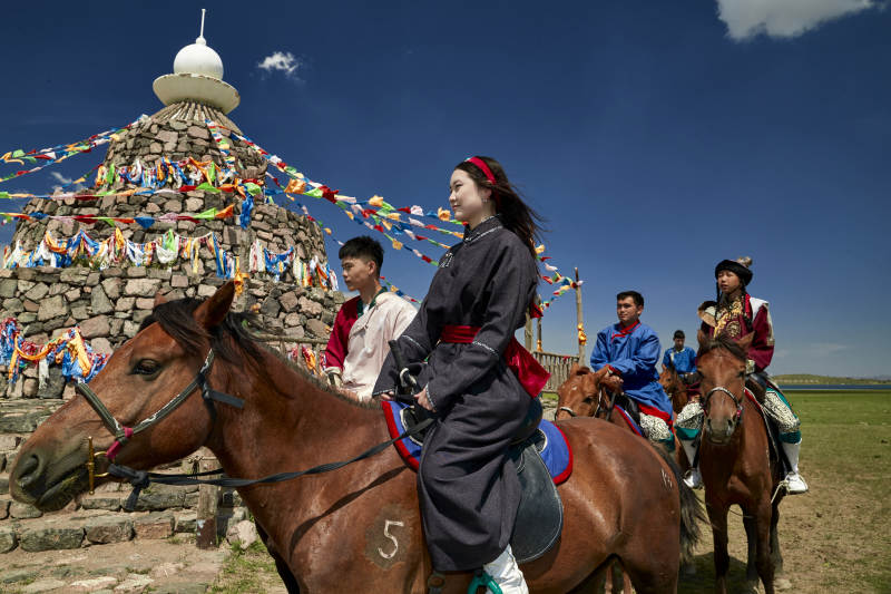 草原那达慕大会上骑着马的蒙古演员