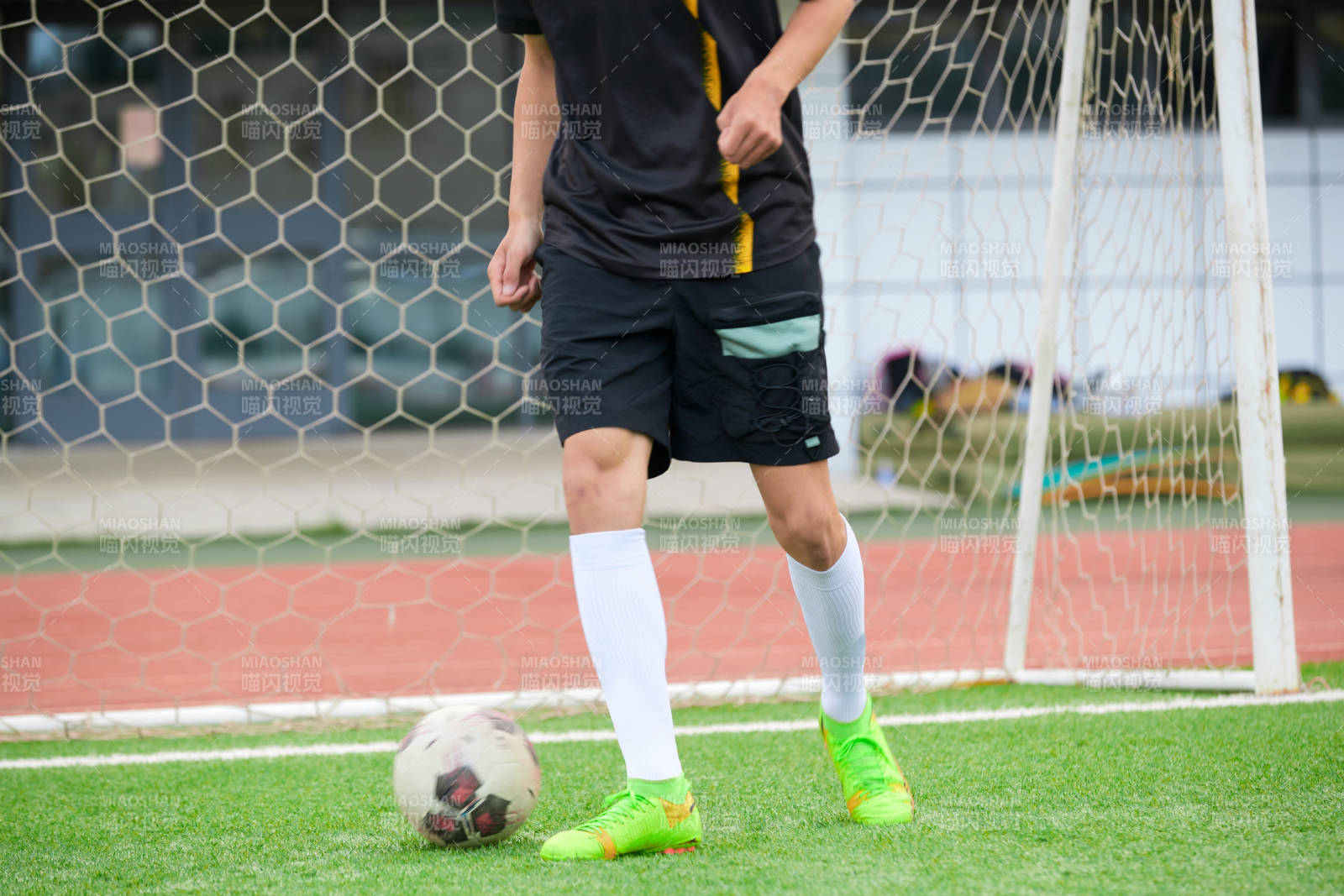 户外足球场上踢足球的运动员