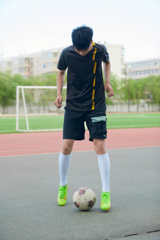 户外足球场上踢足球的运动员