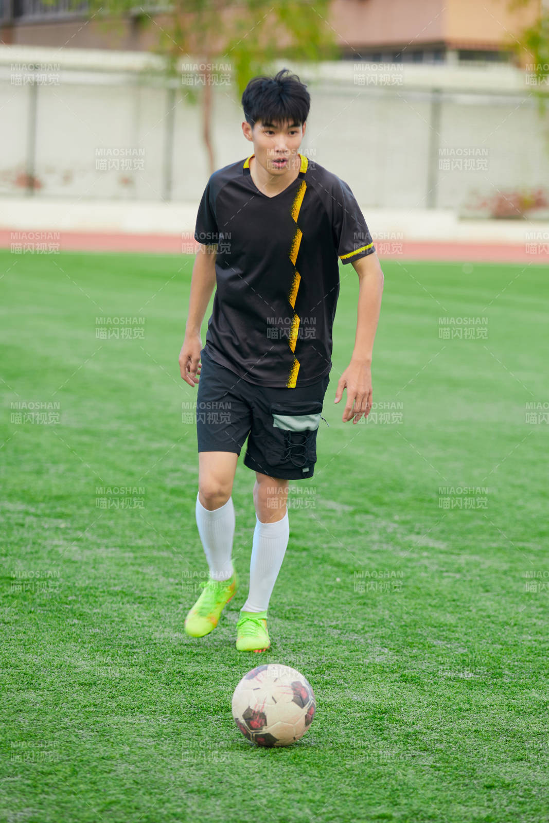 户外足球场上踢足球的运动员