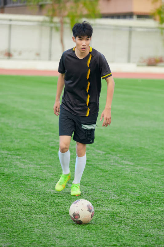 户外足球场上踢足球的运动员