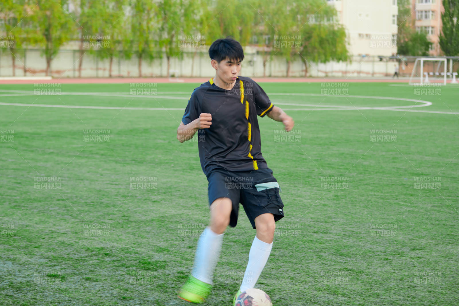 户外足球场上踢足球的运动员