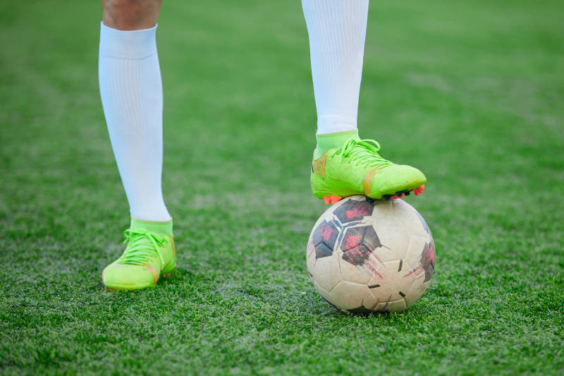 户外足球场上踢足球的运动员