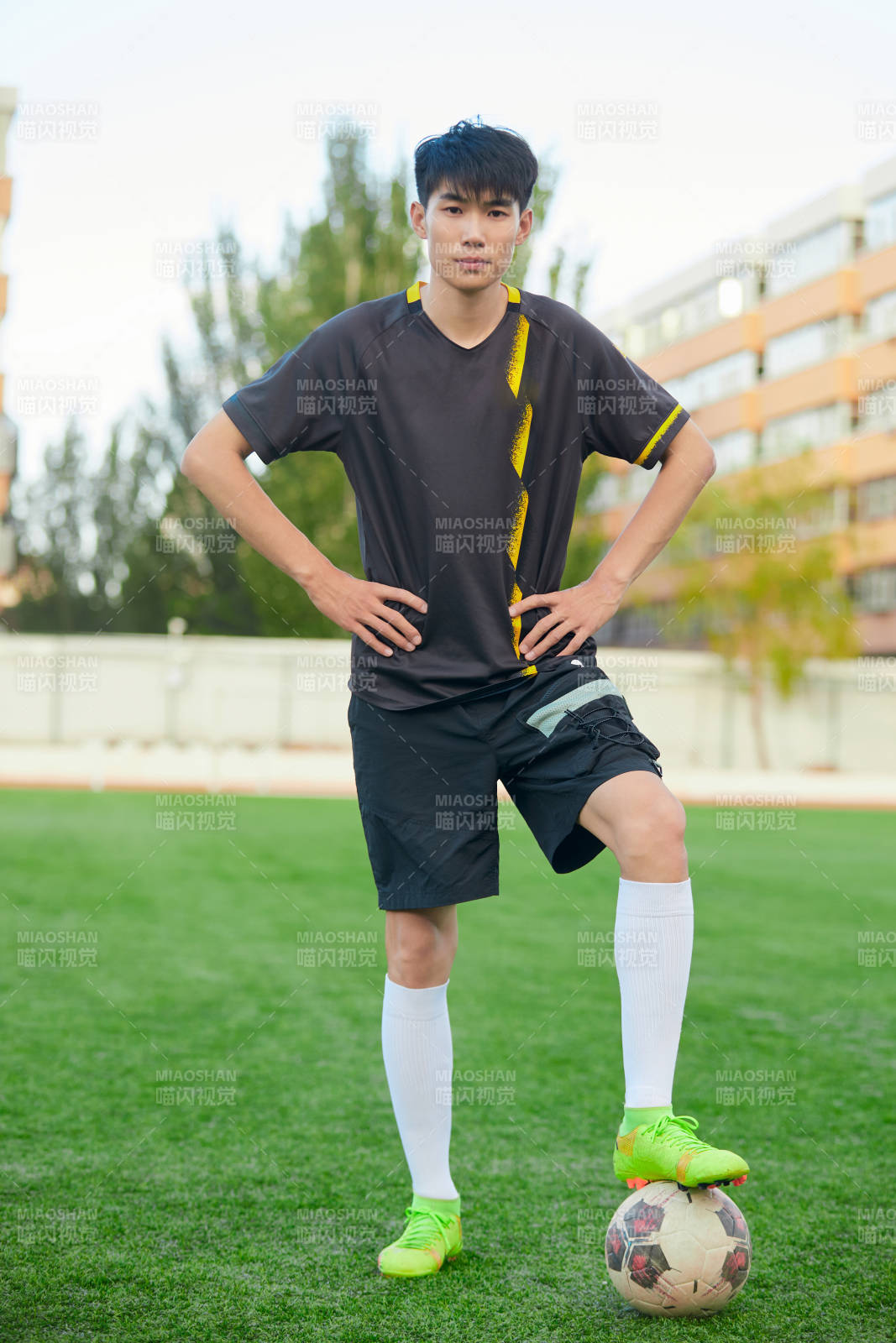 户外足球场上踢足球的运动员