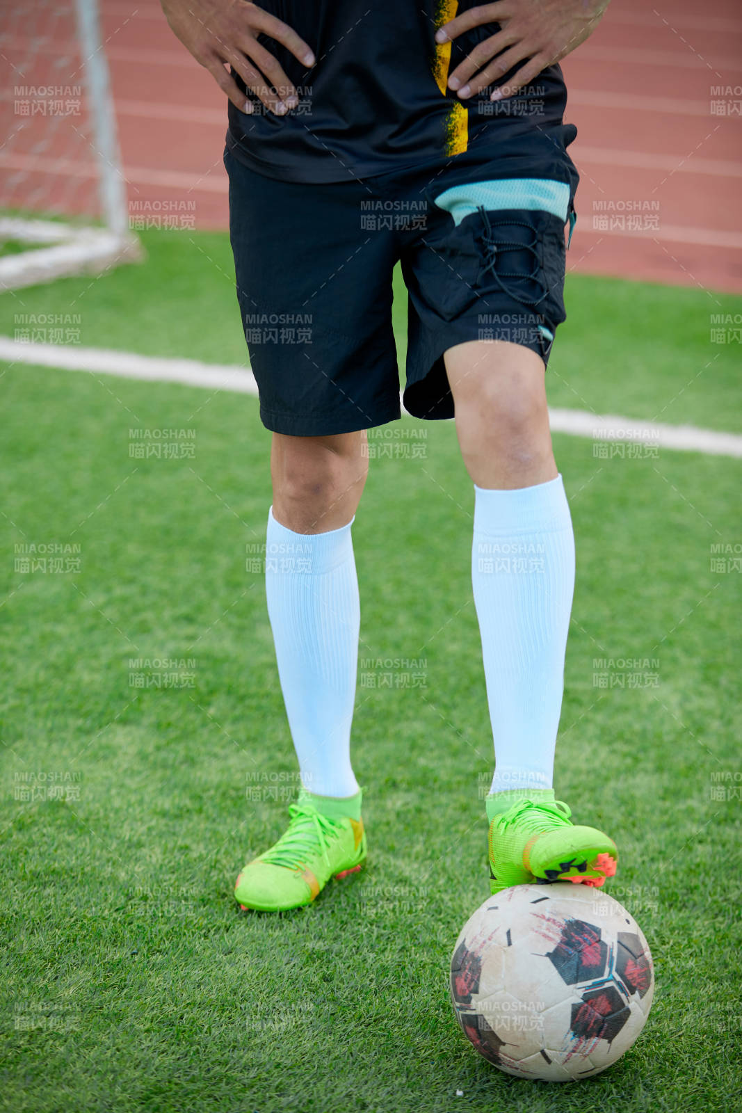 户外足球场上踢足球的运动员