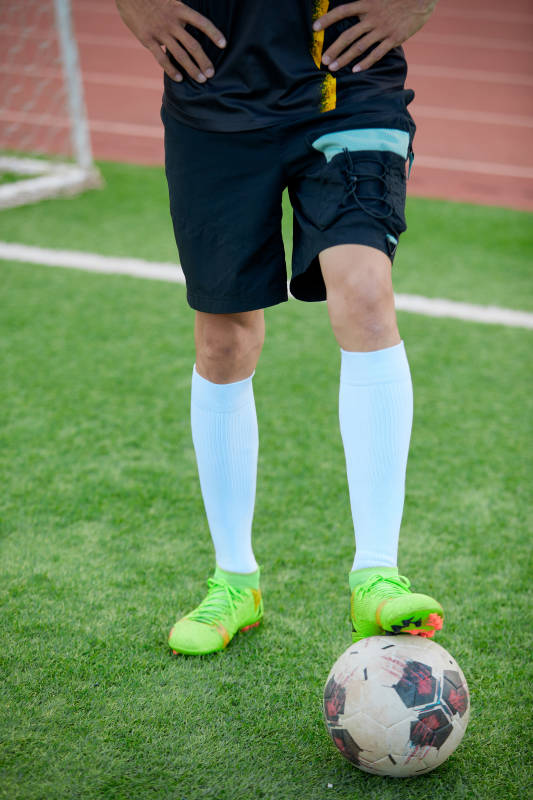 户外足球场上踢足球的运动员