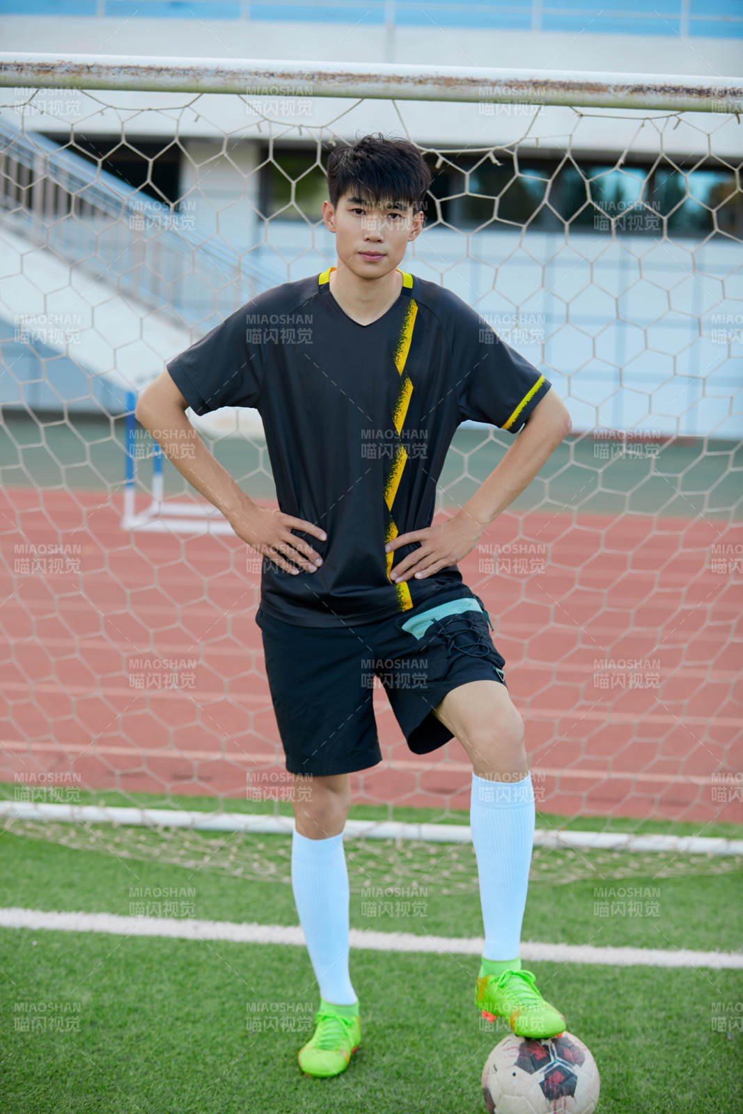戶外足球場(chǎng)上踢足球的運(yùn)動(dòng)員