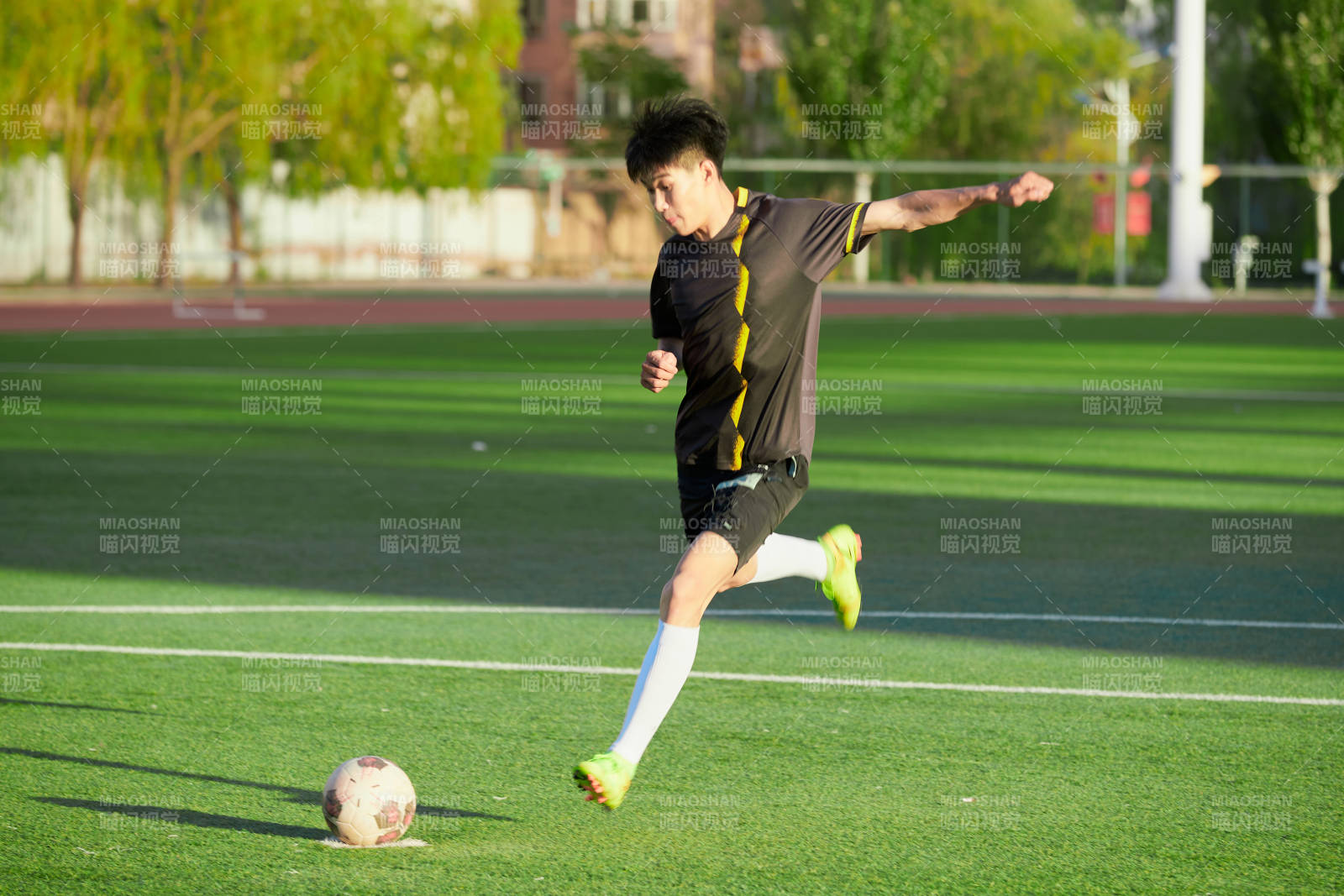 戶外足球場上踢足球的運動員