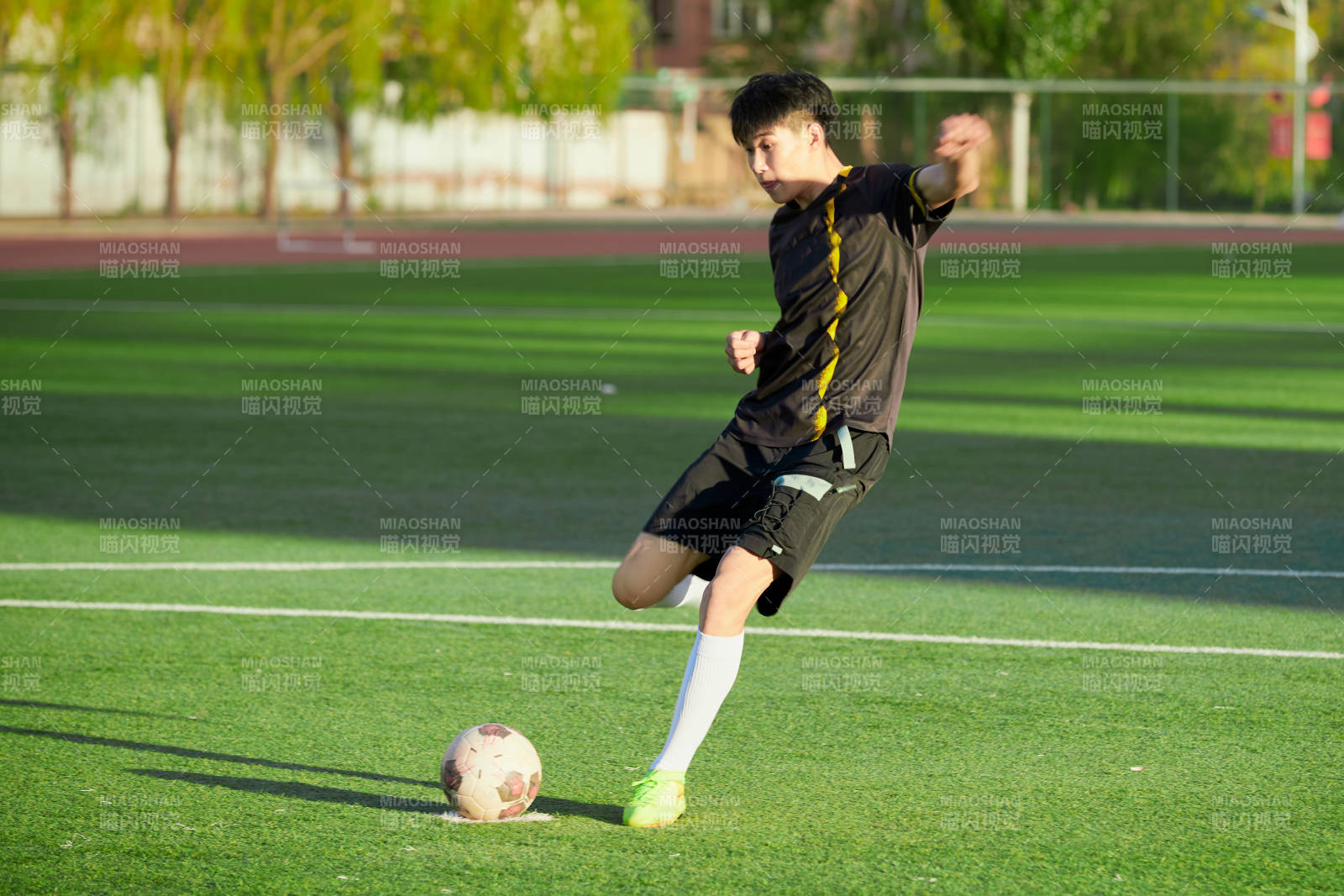 户外足球场上踢足球的运动员