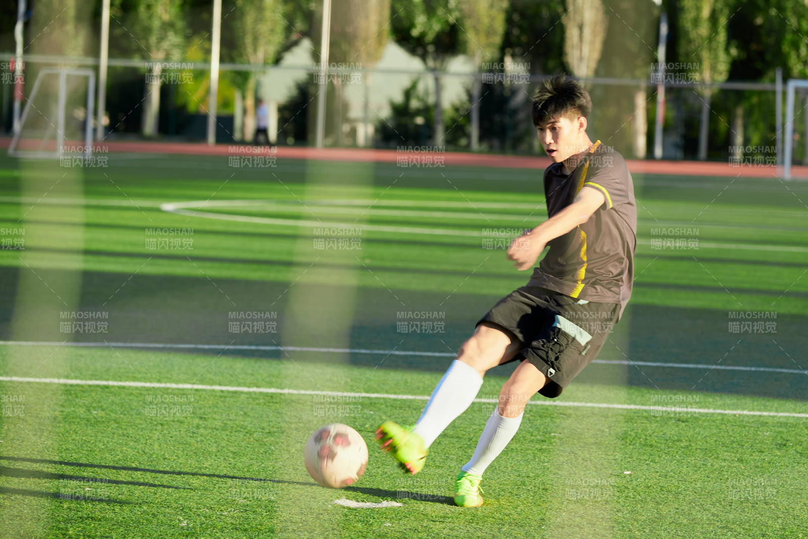 户外足球场上踢足球的运动员