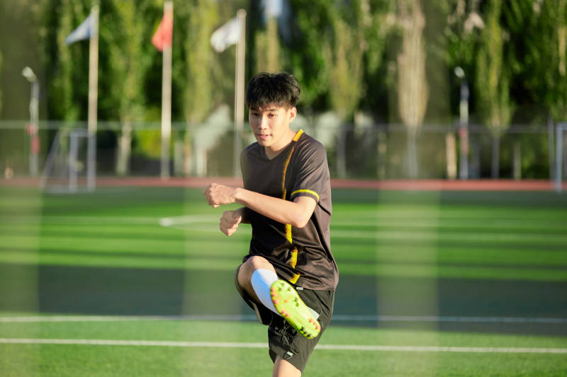 户外足球场上踢足球的运动员