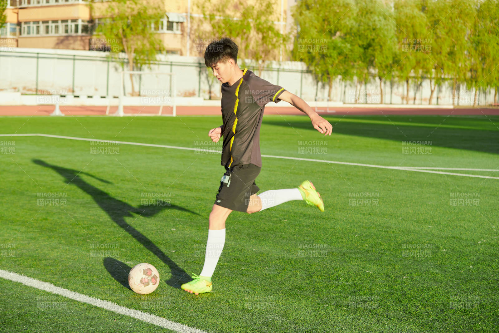 户外足球场上踢足球的运动员