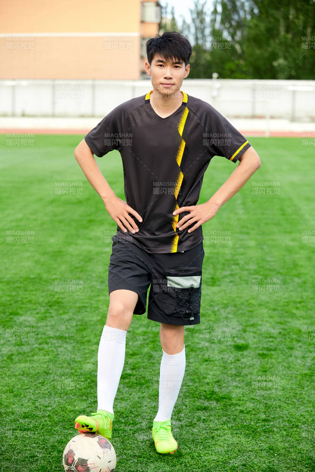 戶外足球場上踢足球的運動員