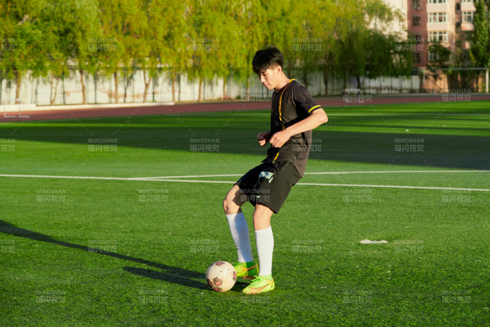 戶外足球場上踢足球的運動員