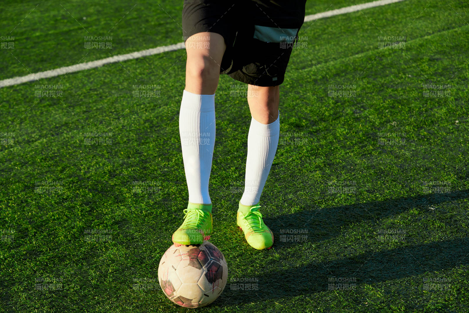 戶外足球場上踢足球的運動員