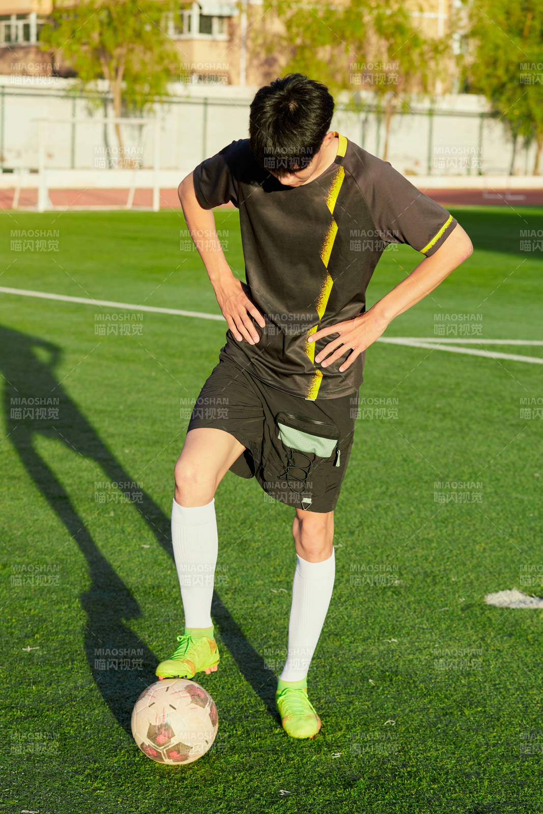 戶外足球場上踢足球的運動員
