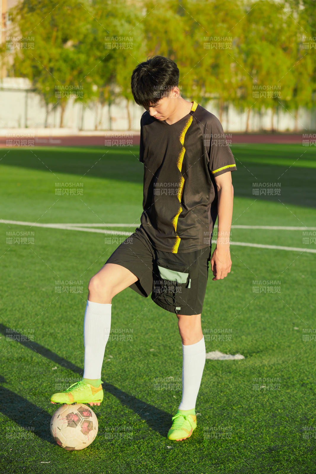 戶外足球場上踢足球的運動員