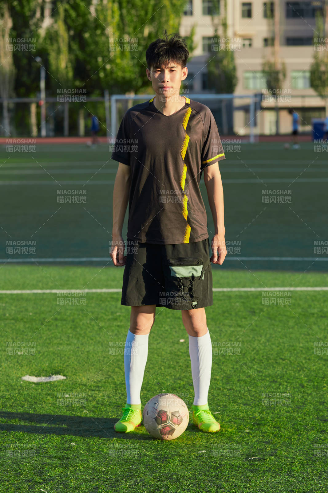戶外足球場上踢足球的運動員