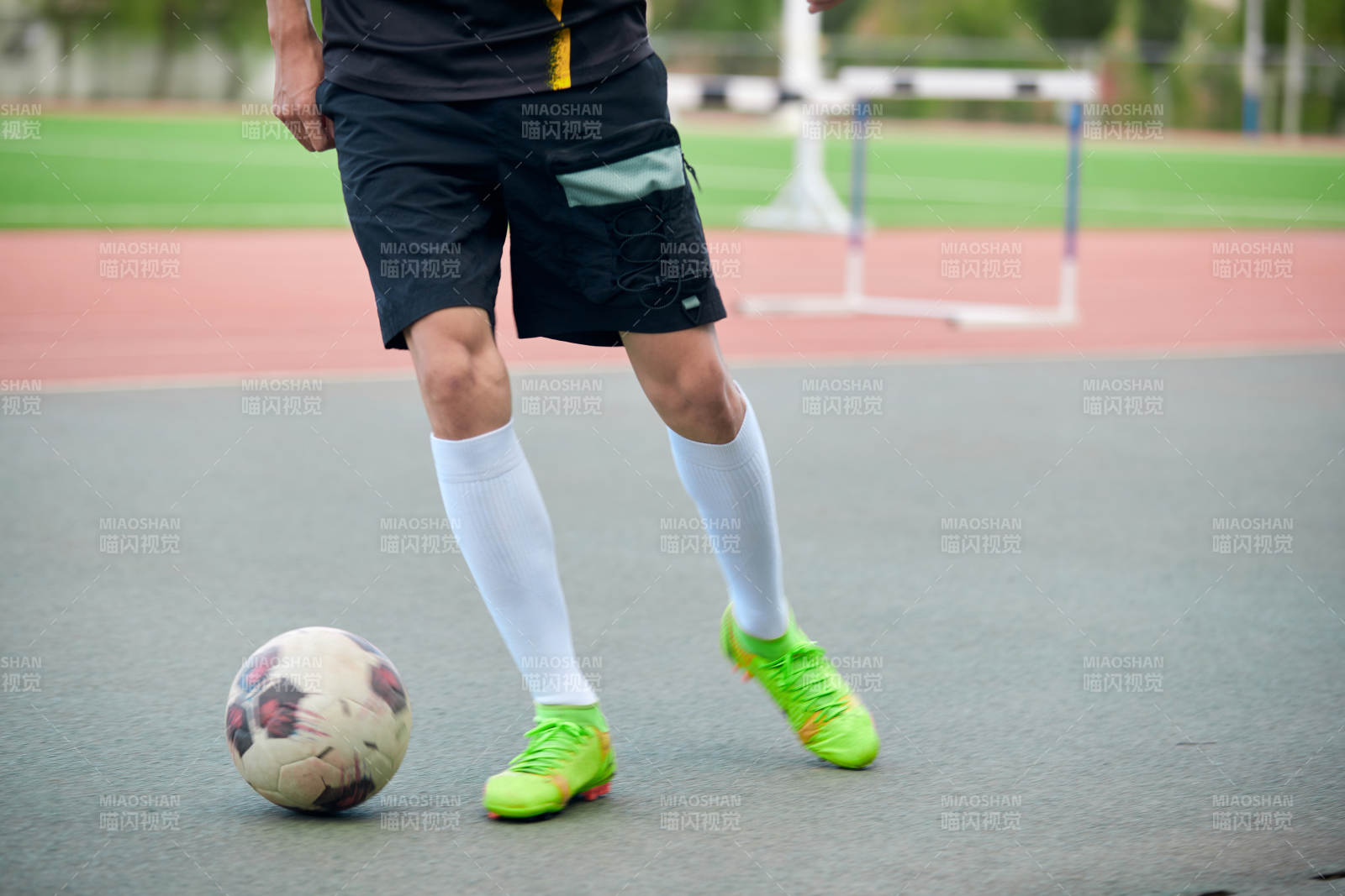 戶外足球場上踢足球的運動員