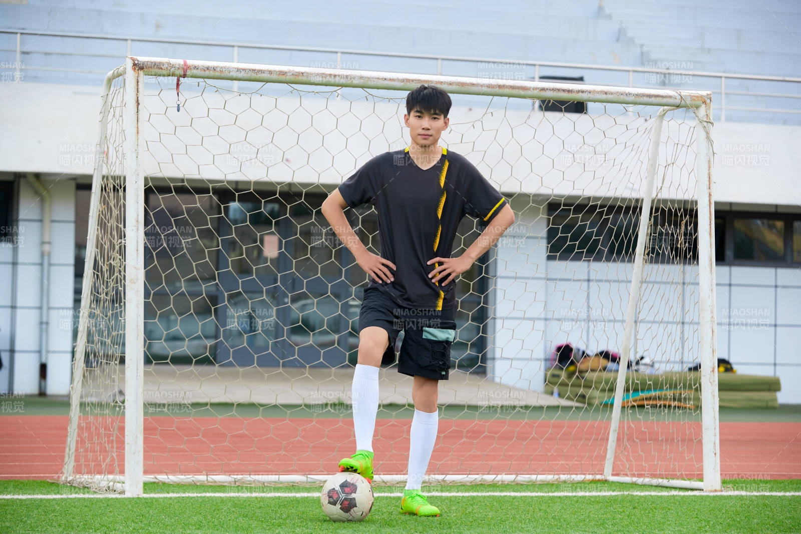 戶外足球場上踢足球的運動員