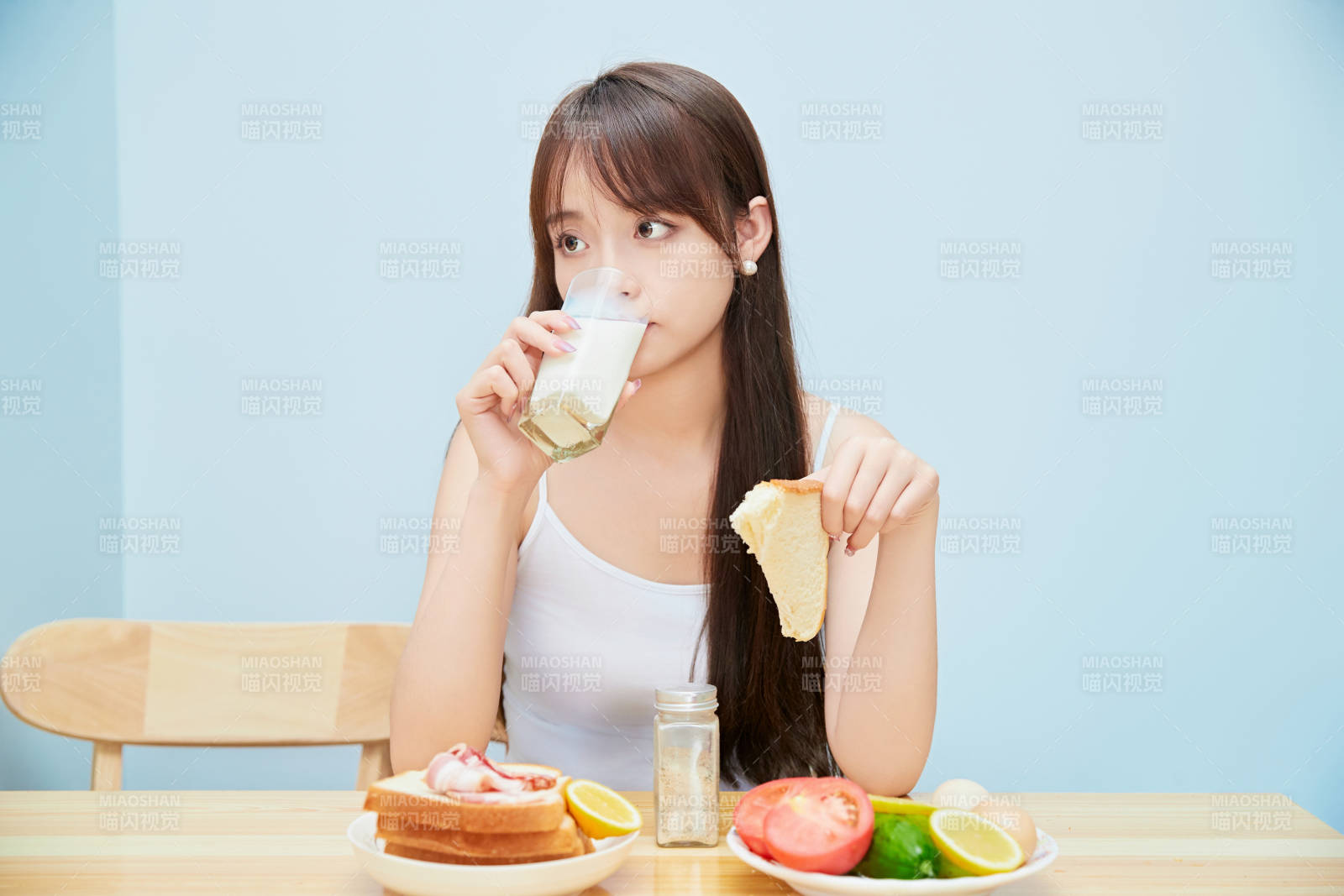 美丽的少女在餐桌前吃早餐