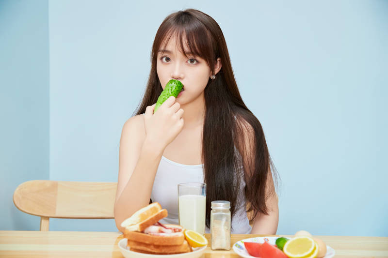 美丽的少女在餐桌前吃早餐