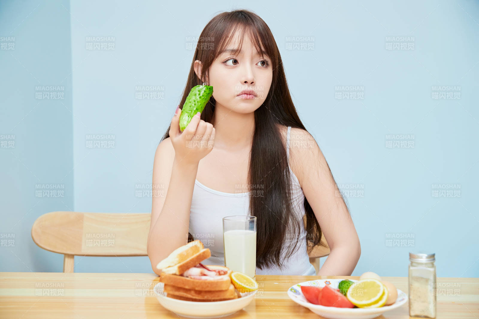 美丽的少女在餐桌前吃早餐