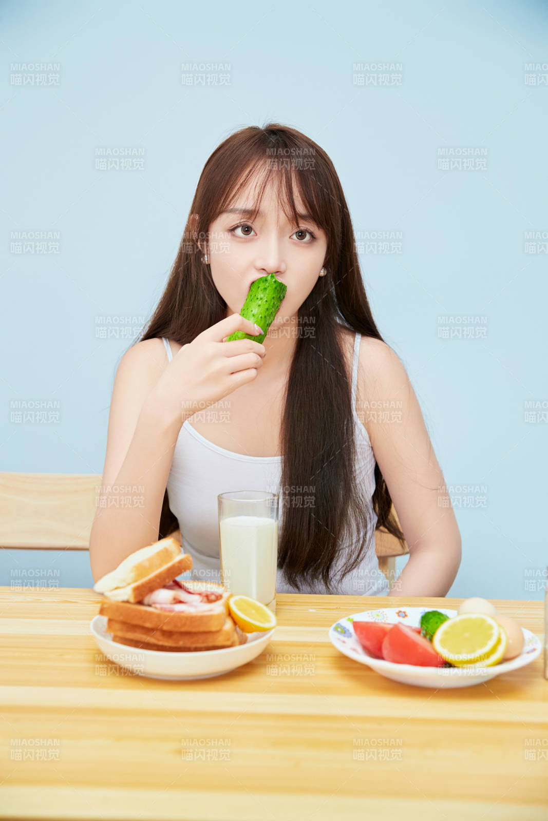 美丽的少女在餐桌前吃早餐