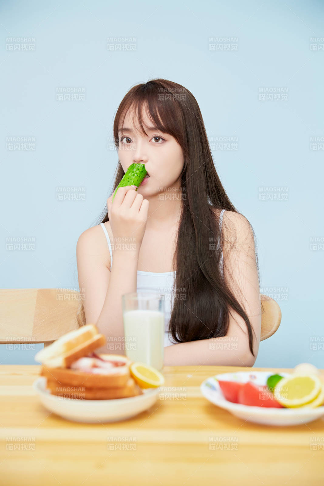 美丽的少女在餐桌前吃早餐