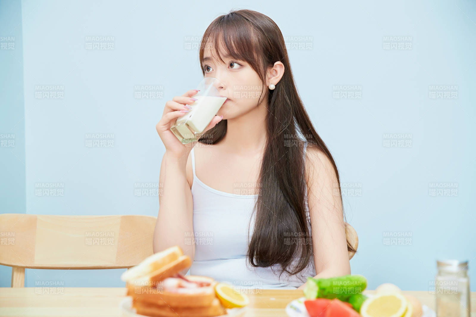 美丽的少女在餐桌前吃早餐