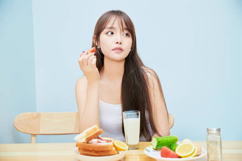 美丽的少女在餐桌前吃早餐