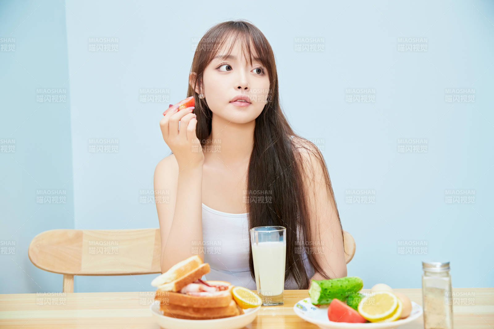 美丽的少女在餐桌前吃早餐