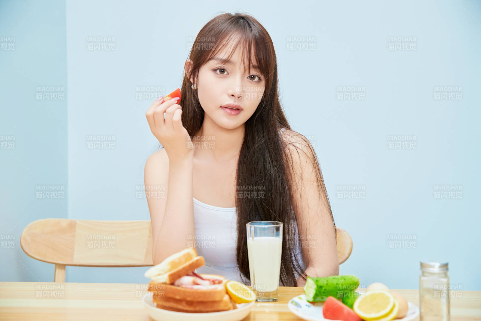 美丽的少女在餐桌前吃早餐