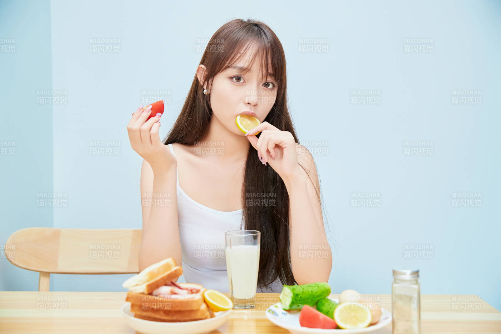 美丽的少女在餐桌前吃早餐