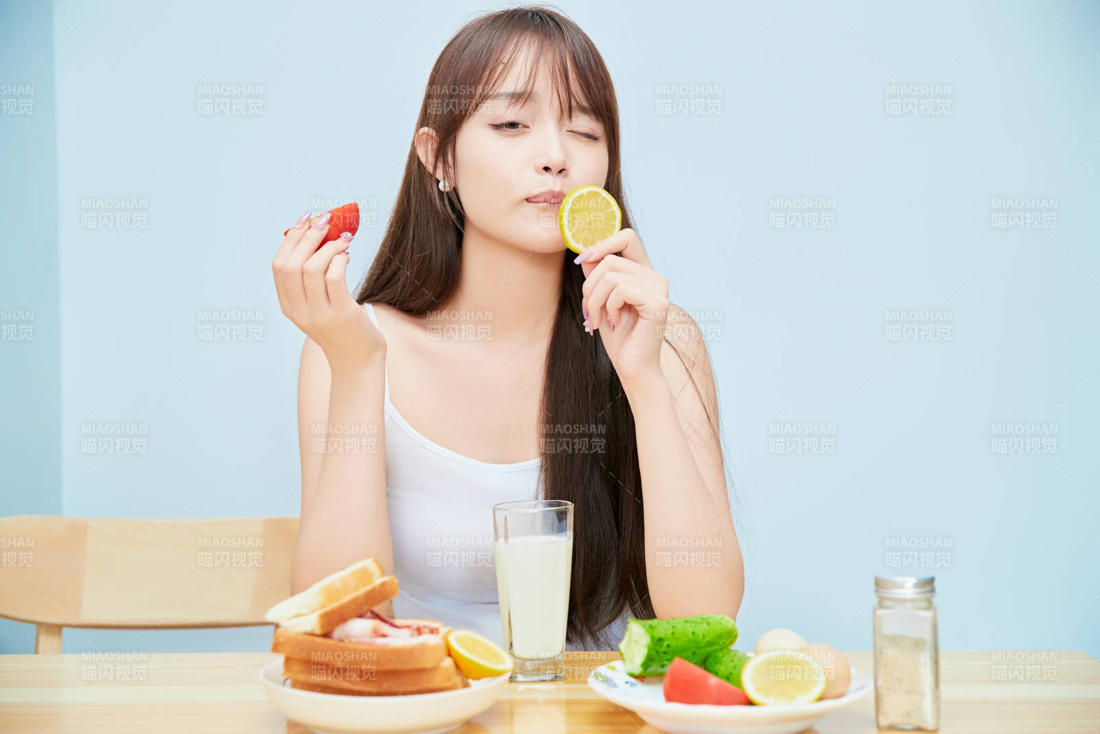 美丽的少女在餐桌前吃早餐