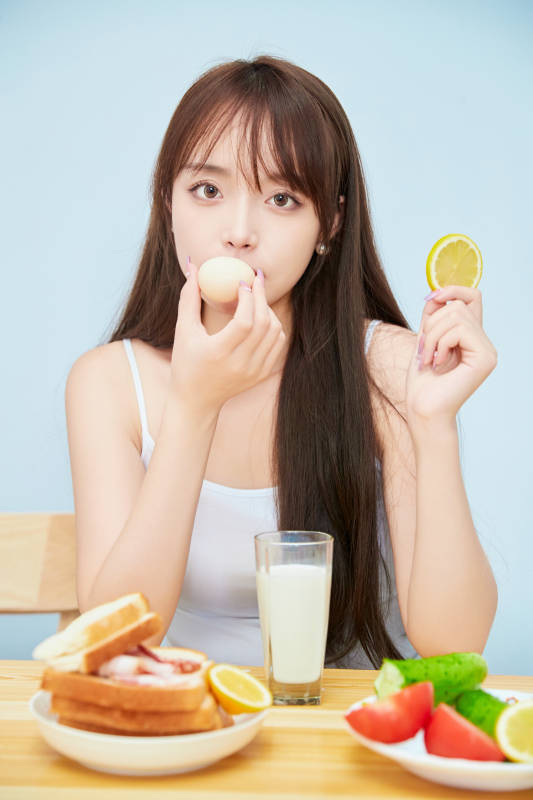 美丽的少女在餐桌前吃早餐