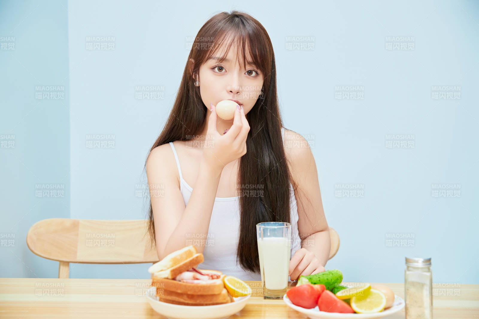 美丽的少女在餐桌前吃早餐